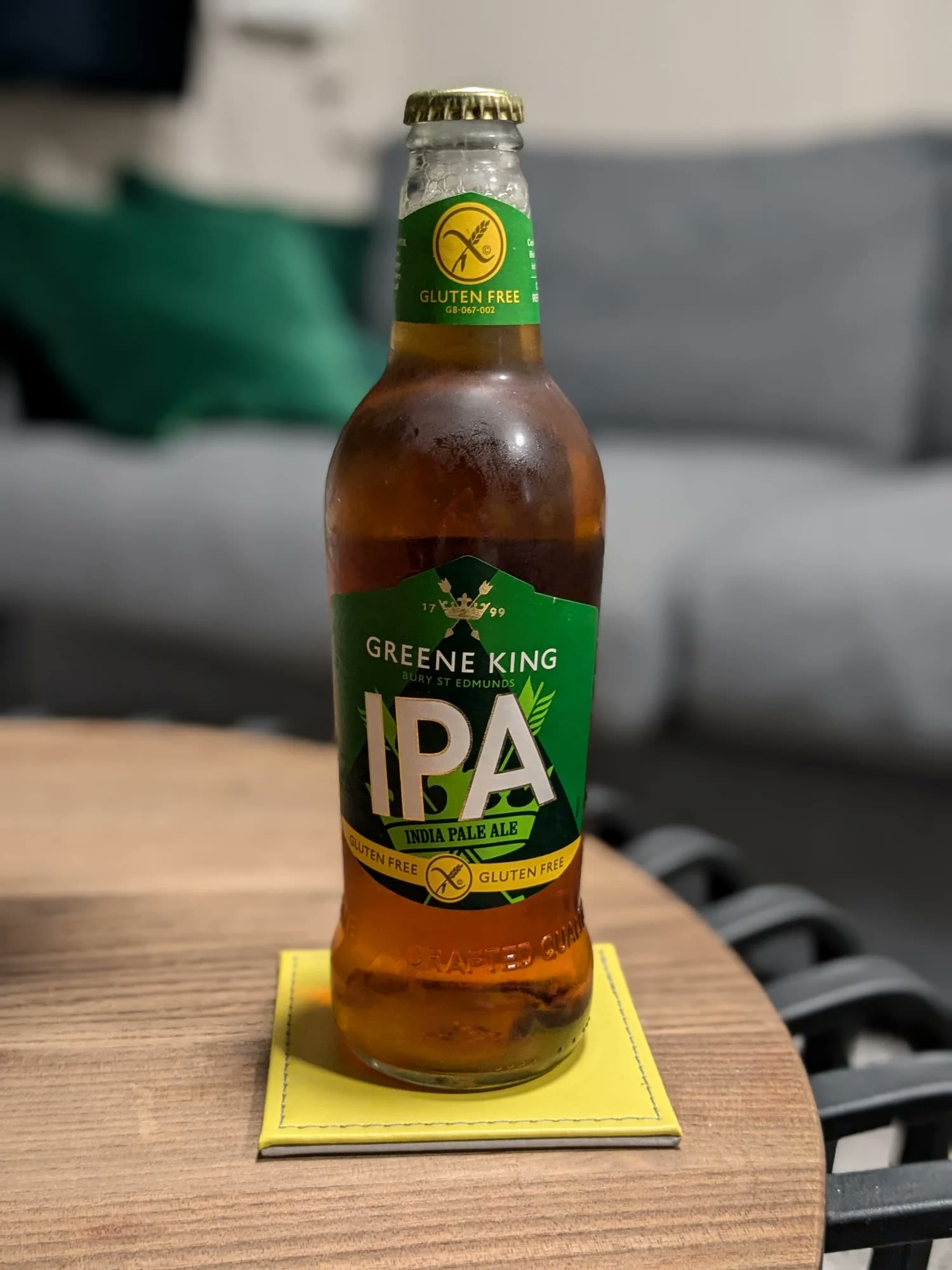 A bottle of gluten-free Greene King IPA on a coaster.