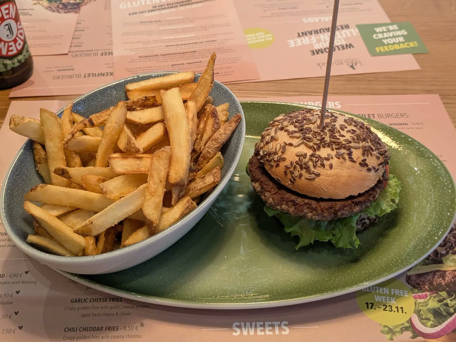 A burger with fries on a green plate at Hans im Glück.